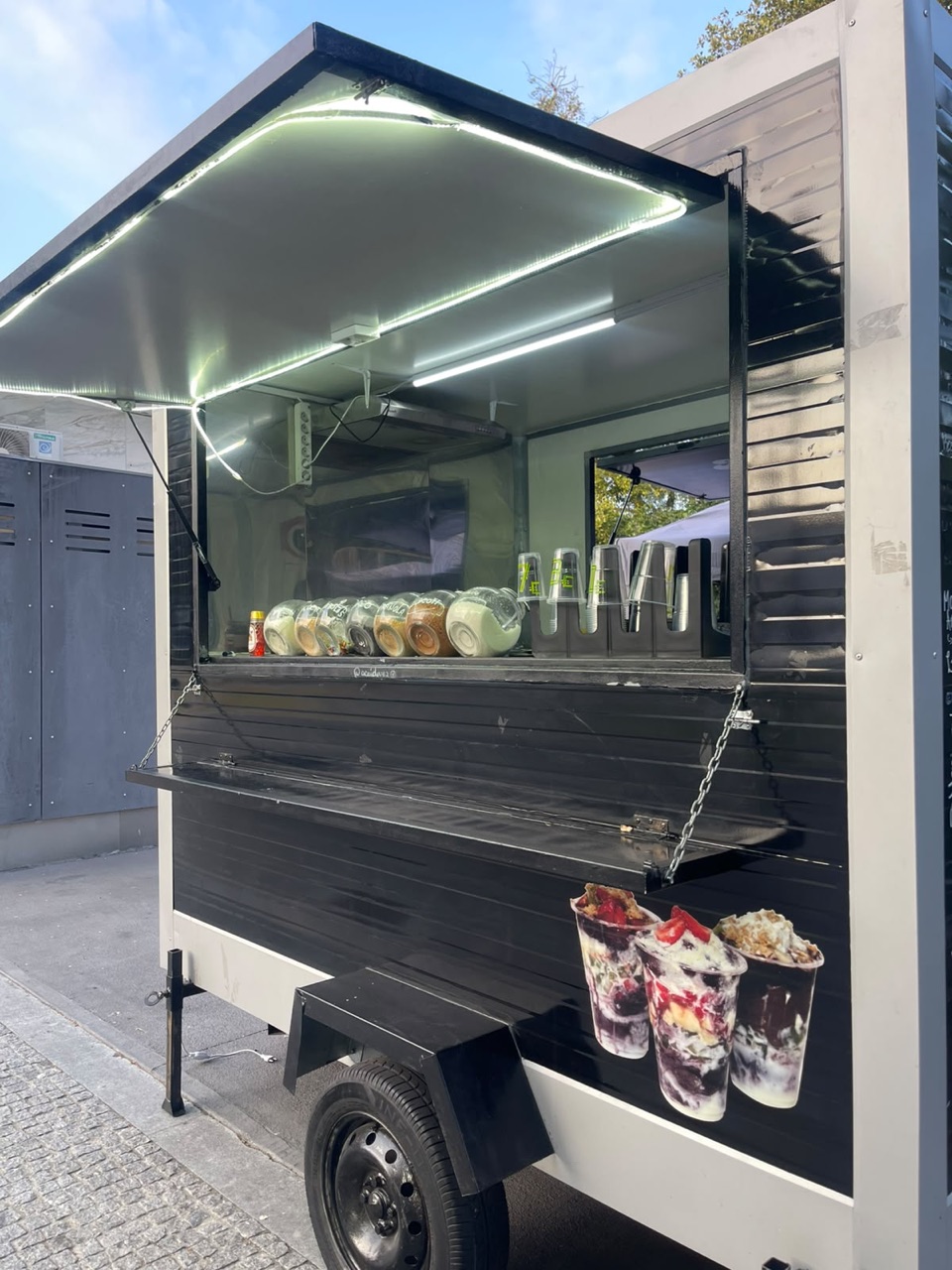 Balcão da roulote com copos e recipientes de toppings